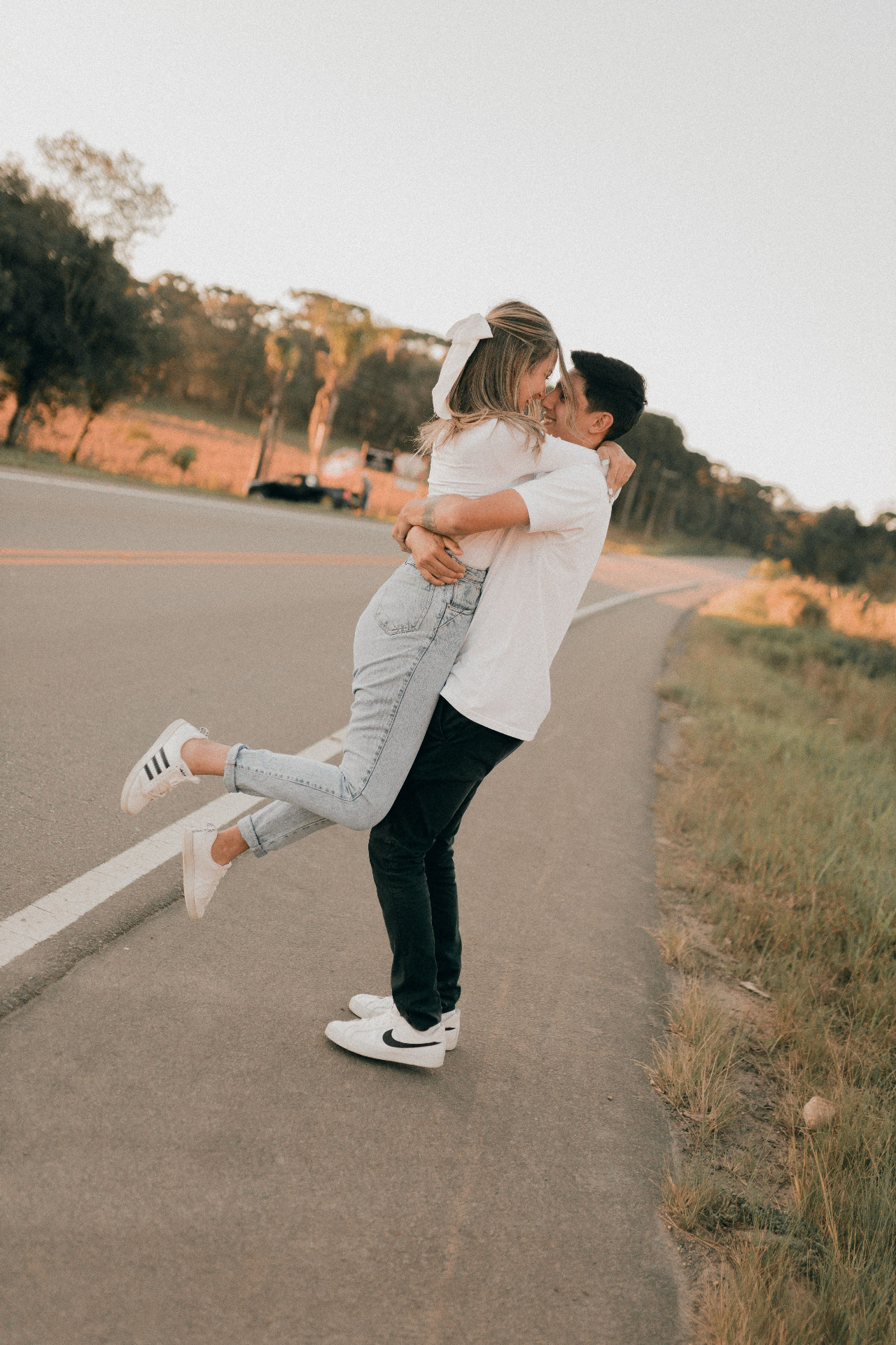 Couple walking together down a sunlit road